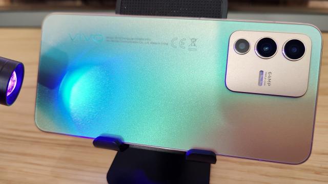 <b>vivo V23 5G: Design de iPhone cu Android, cameleonic şi ergonomic</b>vivo V23 5G e cu siguranţă un telefon memorabil, mai ales în versiunea aurie pe care am testat-o noi. La prima vedere pare un "iPhone cu Android", din cauza muchiilor plate identice cu cele de la iPhone 12 şi 13. Îl dă de gol şi acel breton, e drept mult